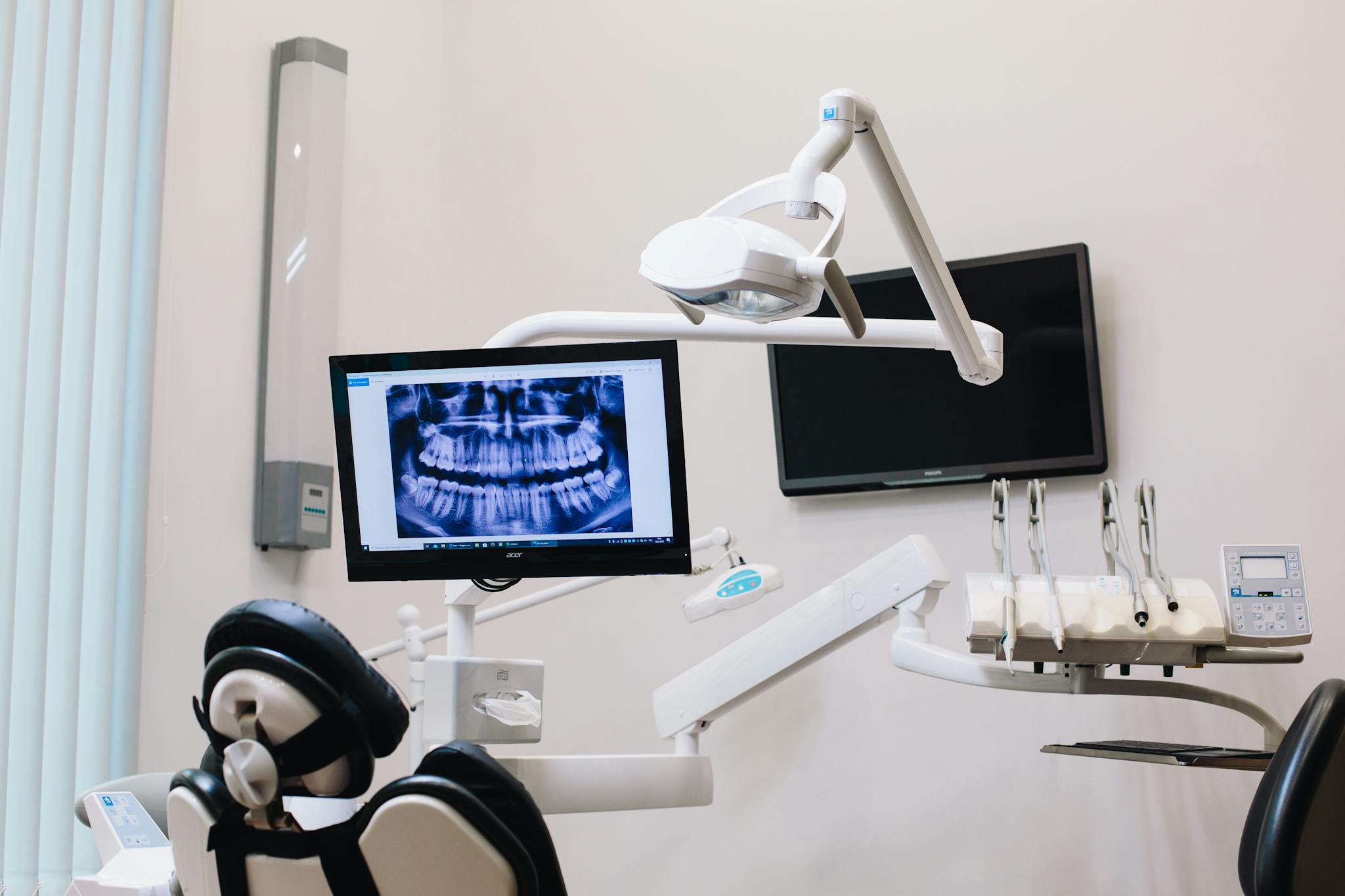 A modern dental office setup featuring an X-ray display on a monitor and advanced dental equipment.